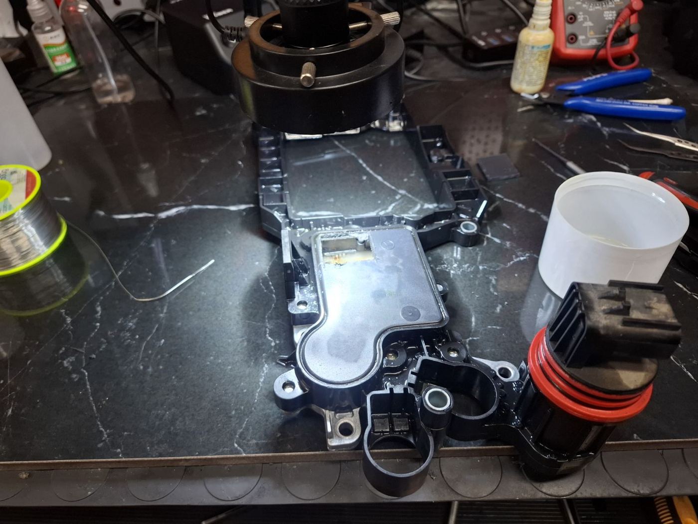 Reparatur einer CVT-Getriebeplatine unter dem Mikroskop
