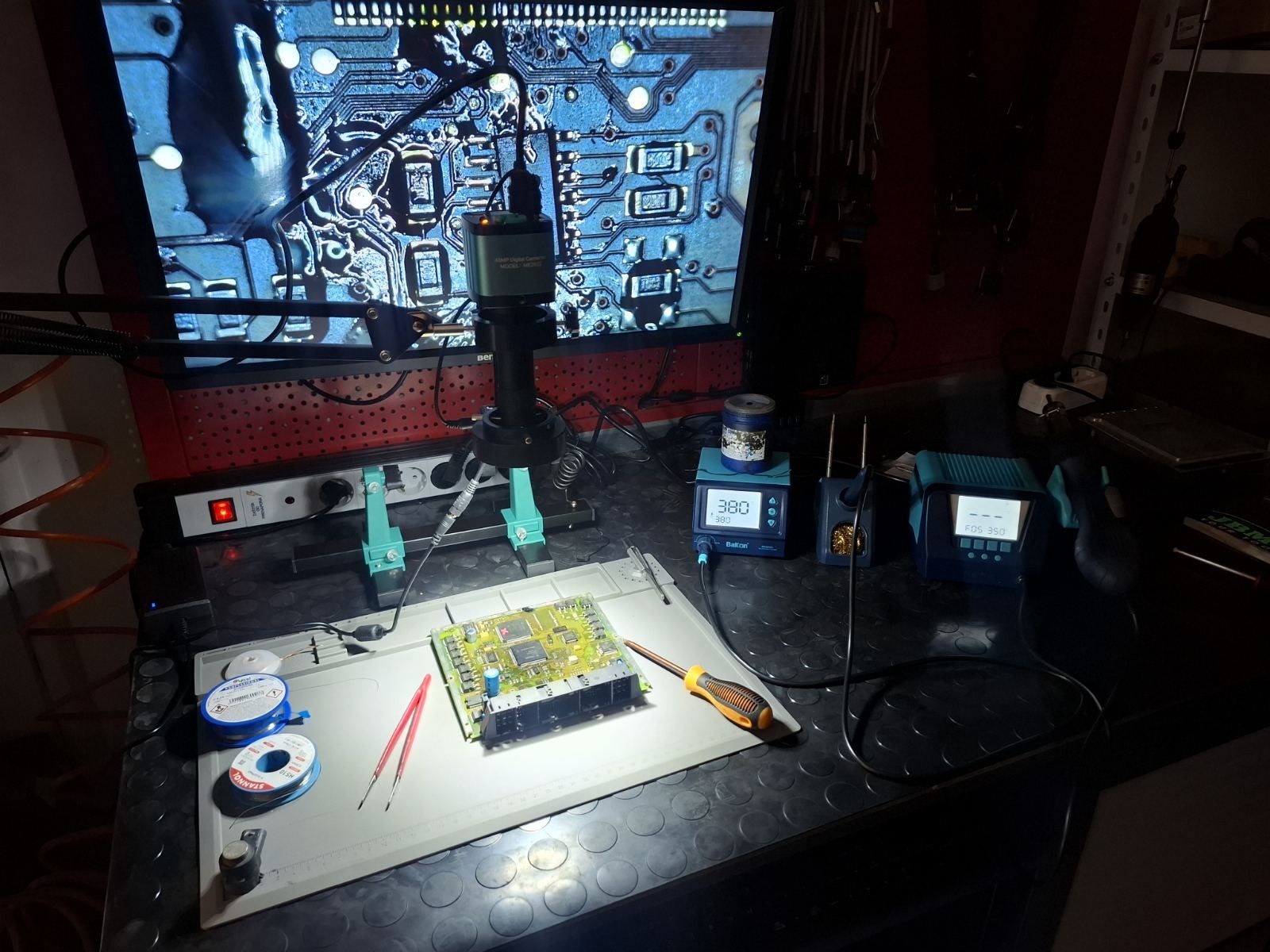 Electronics repair bench: engine control unit under a digital microscope